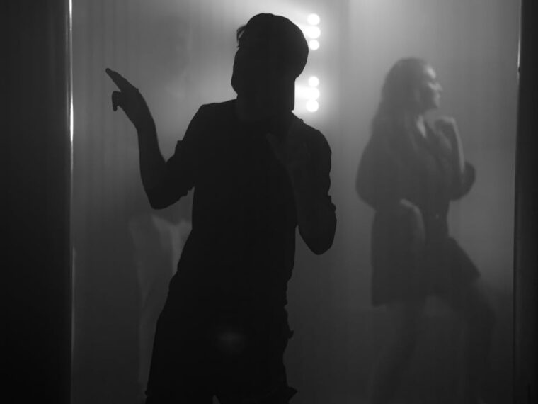 A man is dancing in a dark room