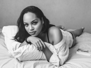 a black and white photo of a woman laying on a bed