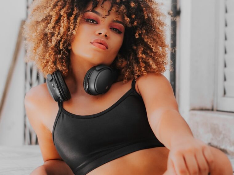 a woman wearing headphones sitting on a ledge