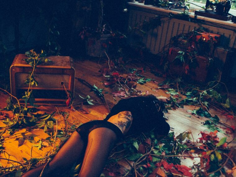 a woman laying on the floor surrounded by leaves