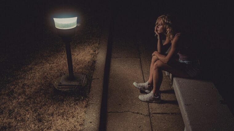 woman in black tank top sitting on concrete floor