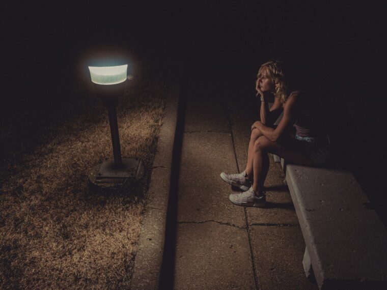 woman in black tank top sitting on concrete floor